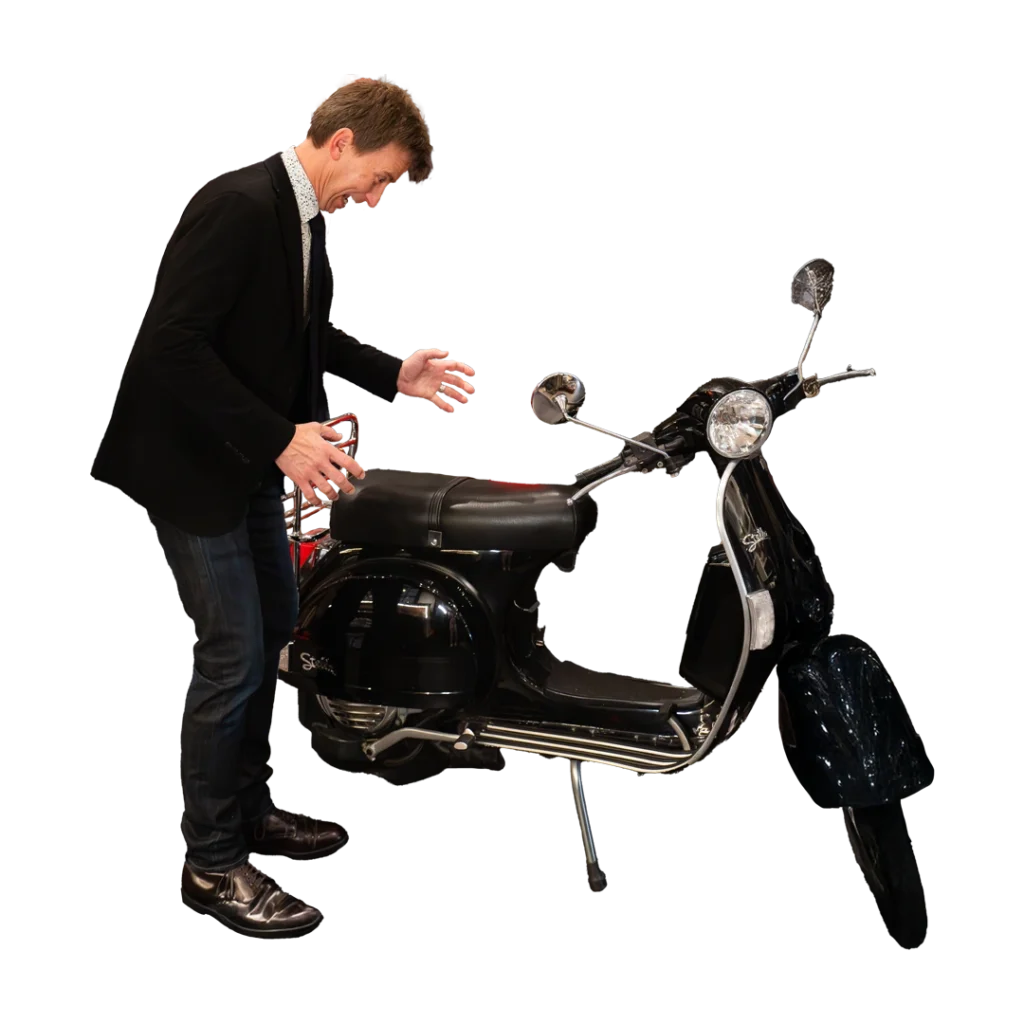 Tim Gabrielson Looks at a moped comically