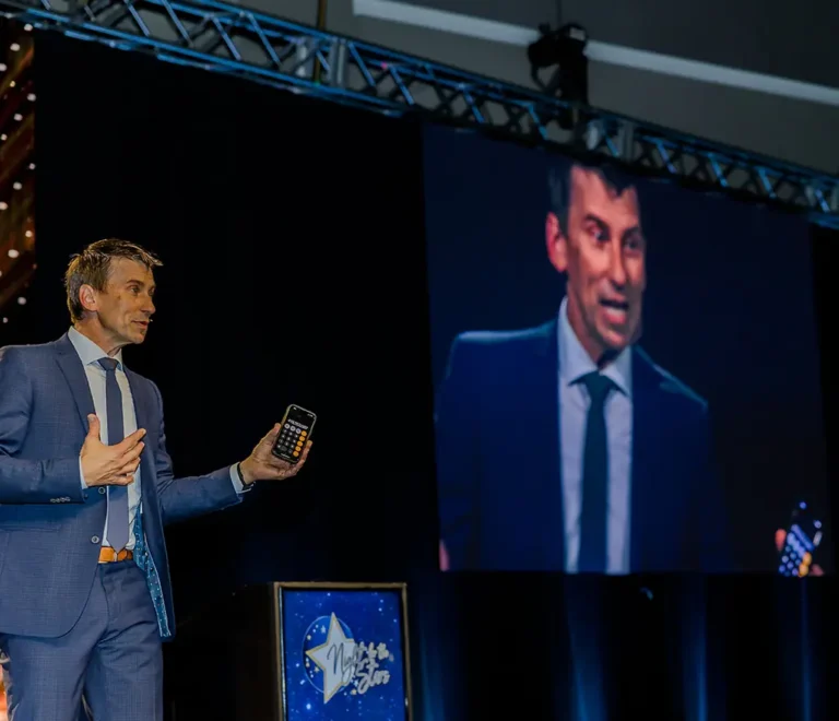 Tim Gabrielson Speaking on Stage with a screen behind him